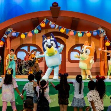 Bluey and Bingo perform on stage for families during Bluey's Best Day Ever show at Disneyland Resort's Fantasyland Theatre.