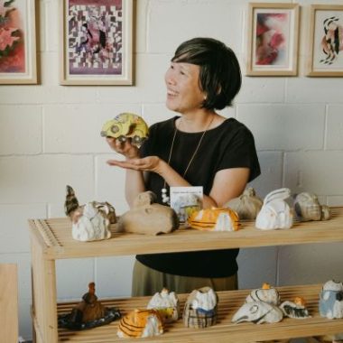 Alyson Iwamoto holds up a ceramic in her ceramics studio.