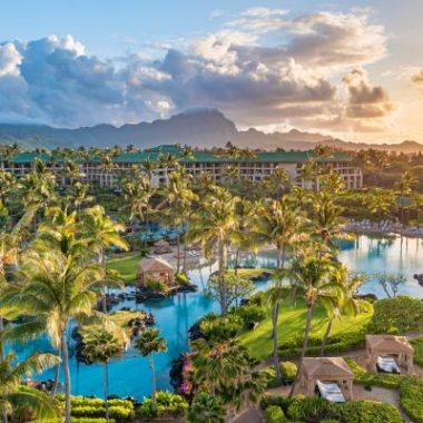 Saltwater lagoon pools and palm trees at Grand Hyatt Kauai Resort & Spa on Kauai’s sunny South Shore at sunset.