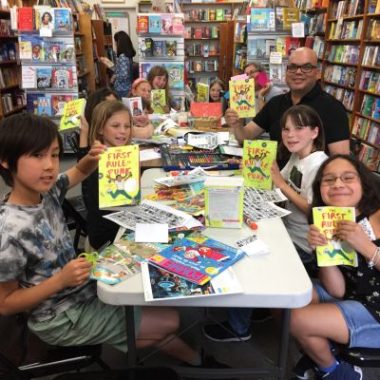 Children hold up books during a book club gathering at Children's Book World in West Los Angeles, a participating bookstore in the Los Angeles Indie Book Crawl.